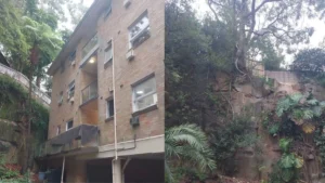 Residential building and rock face after completion of footbridge demolition at Lane Cove North