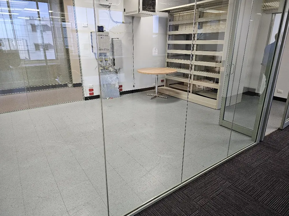 Artarmon meeting room before renovation with its previous flooring and stored items