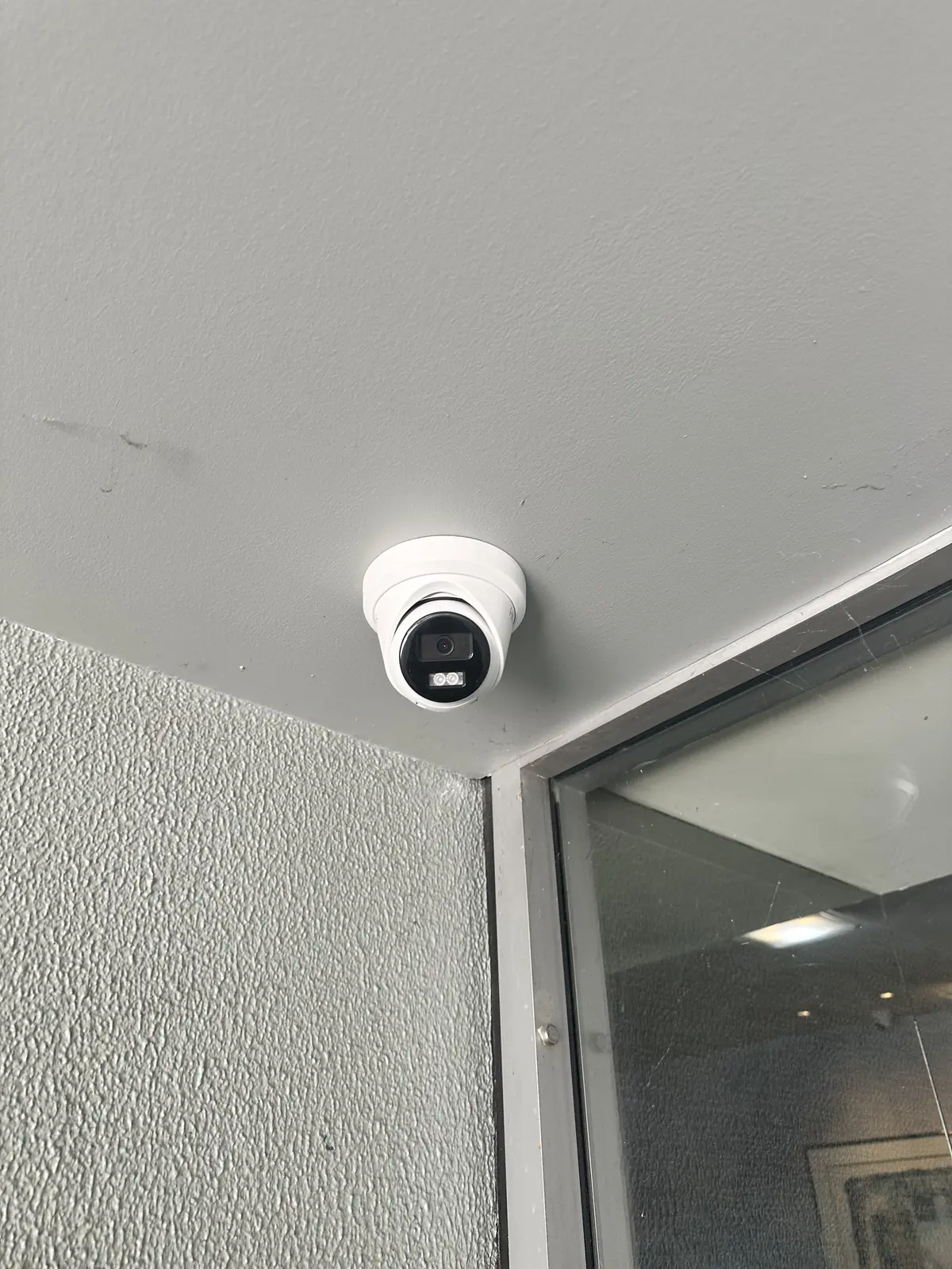 Ceiling-mounted CCTV camera beside a glazed entry at the Artarmon strata property