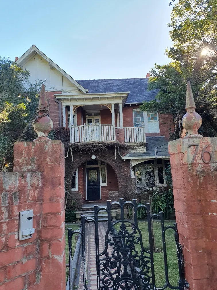 Brick heritage-listed property with decorative timber balcony in Centennial Park