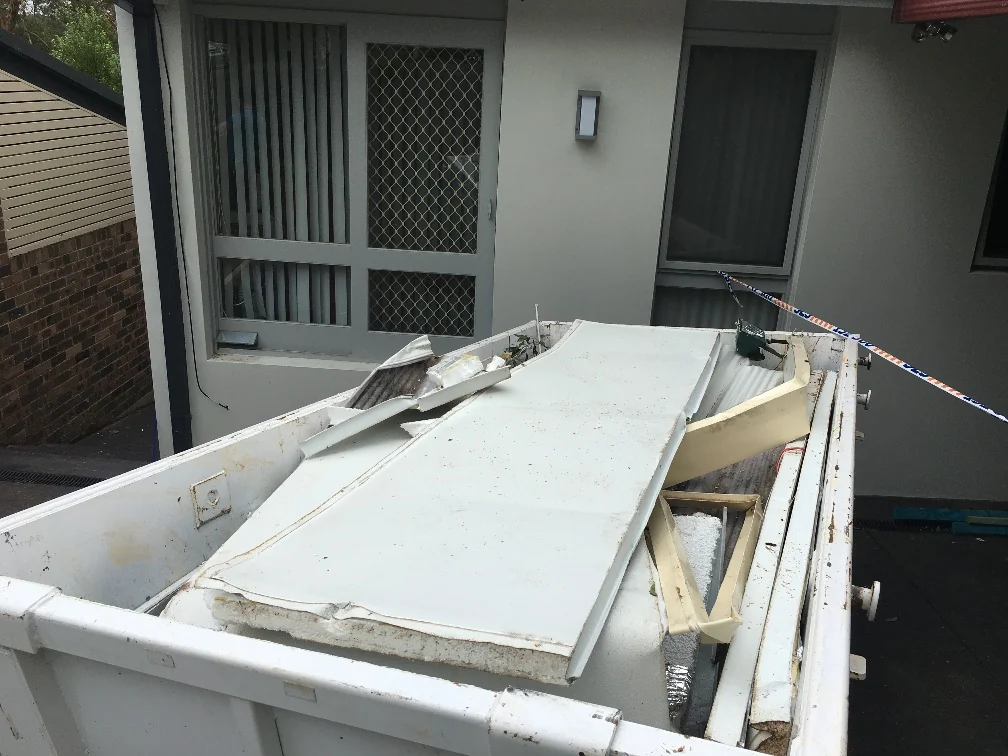 Removed frames and damaged building components gathered outside the Grays Point property