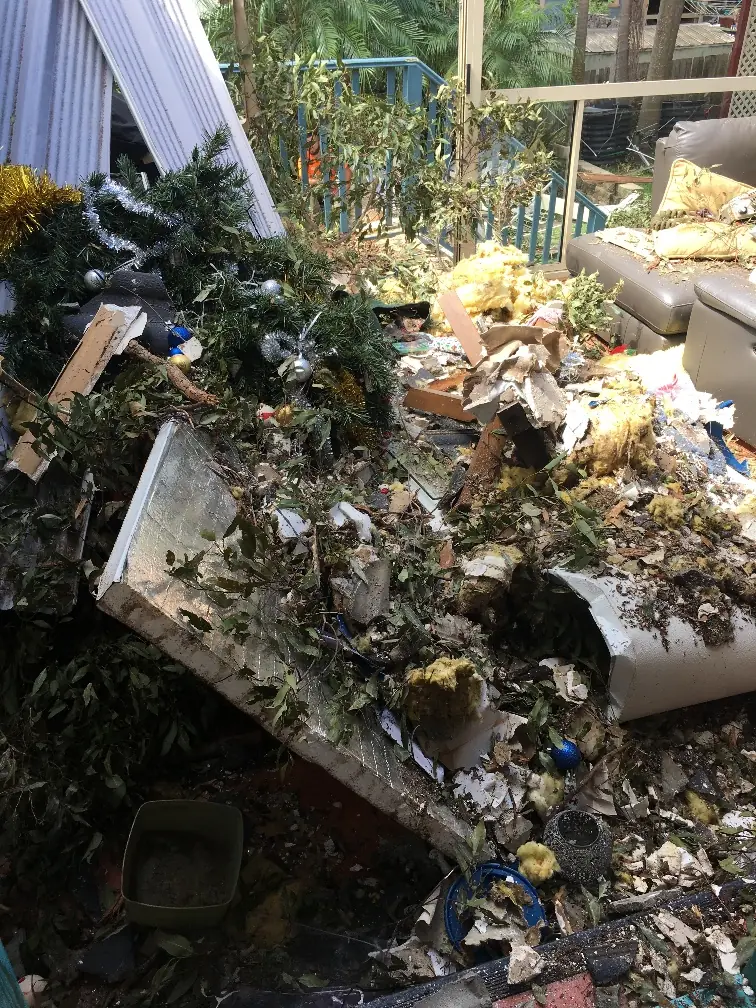 Tree branches and damaged building debris beside the Grays Point property