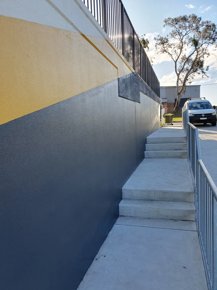 Repaired concrete wall and balustrade beside the industrial complex stairs
