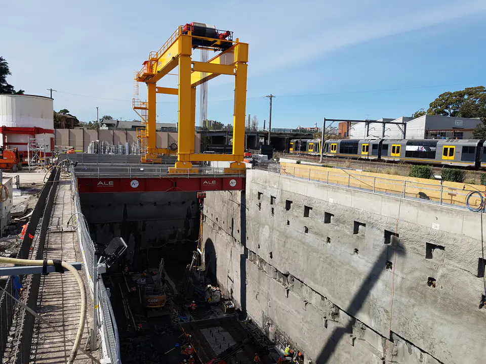 Deep excavation with retaining walls, a gantry crane and railway tracks alongside
