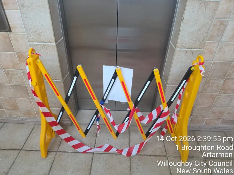 Temporary yellow access barrier beside a lift during the Artarmon common-area works