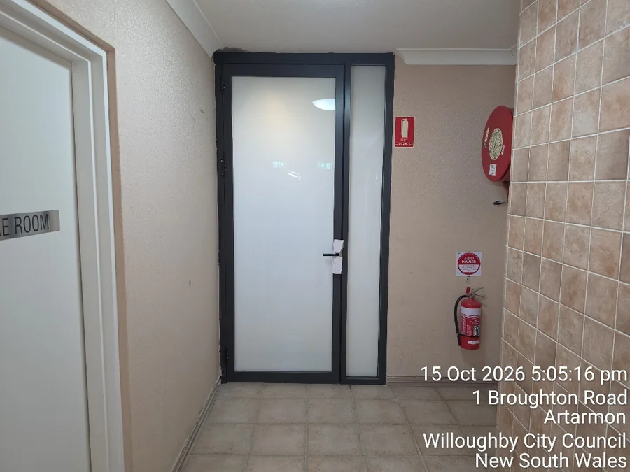 New dark-framed frosted-glass door and side panel in the Artarmon common area